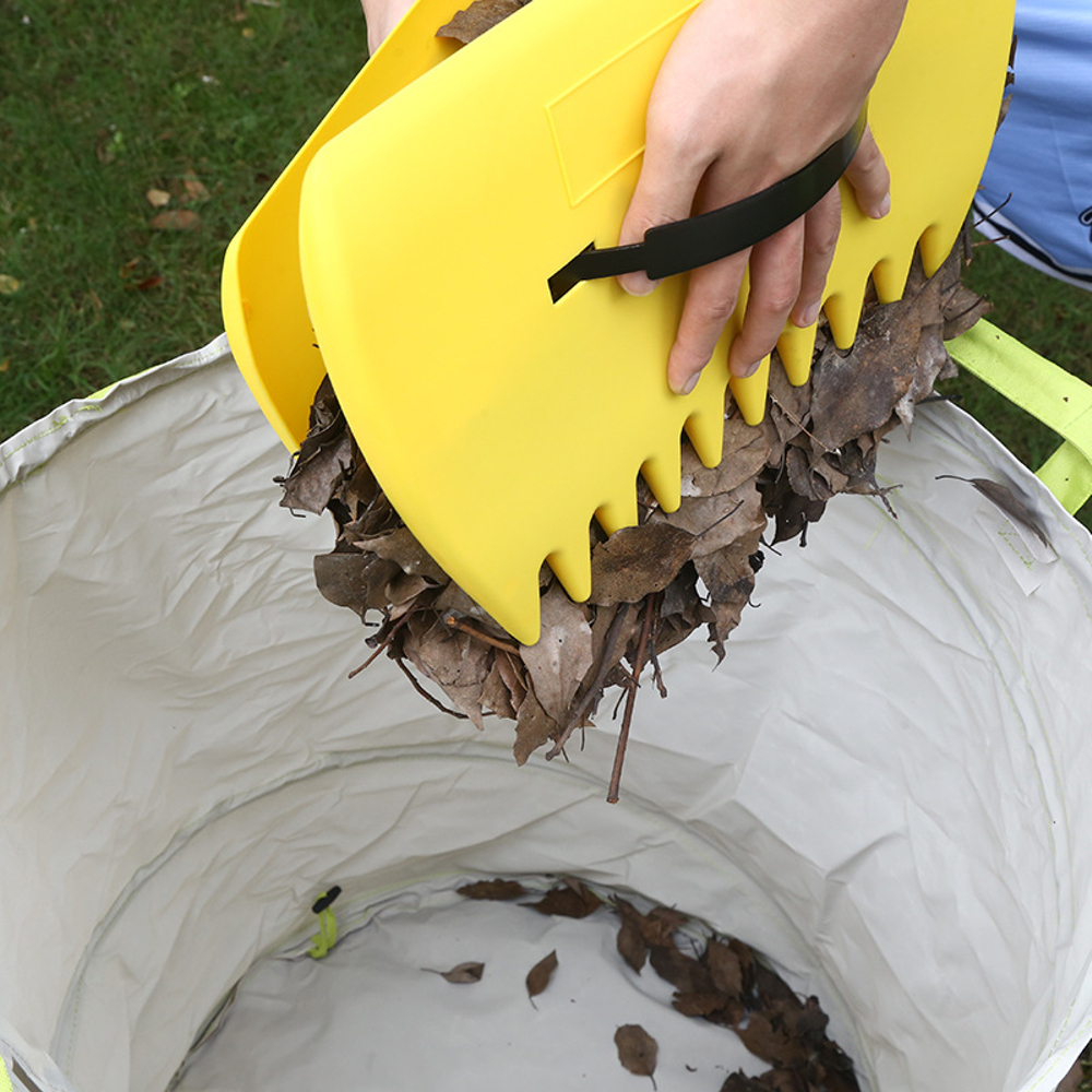 Laubhände entleeren gesammeltes Laub in einen Gartensack